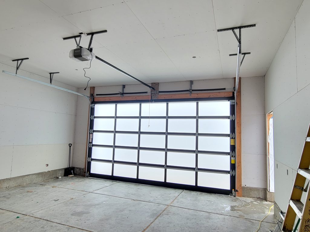 20240122_151521 Expert garage door installation and repair: Interior view of garage with newly installed glass panel door by Homeland Doors.